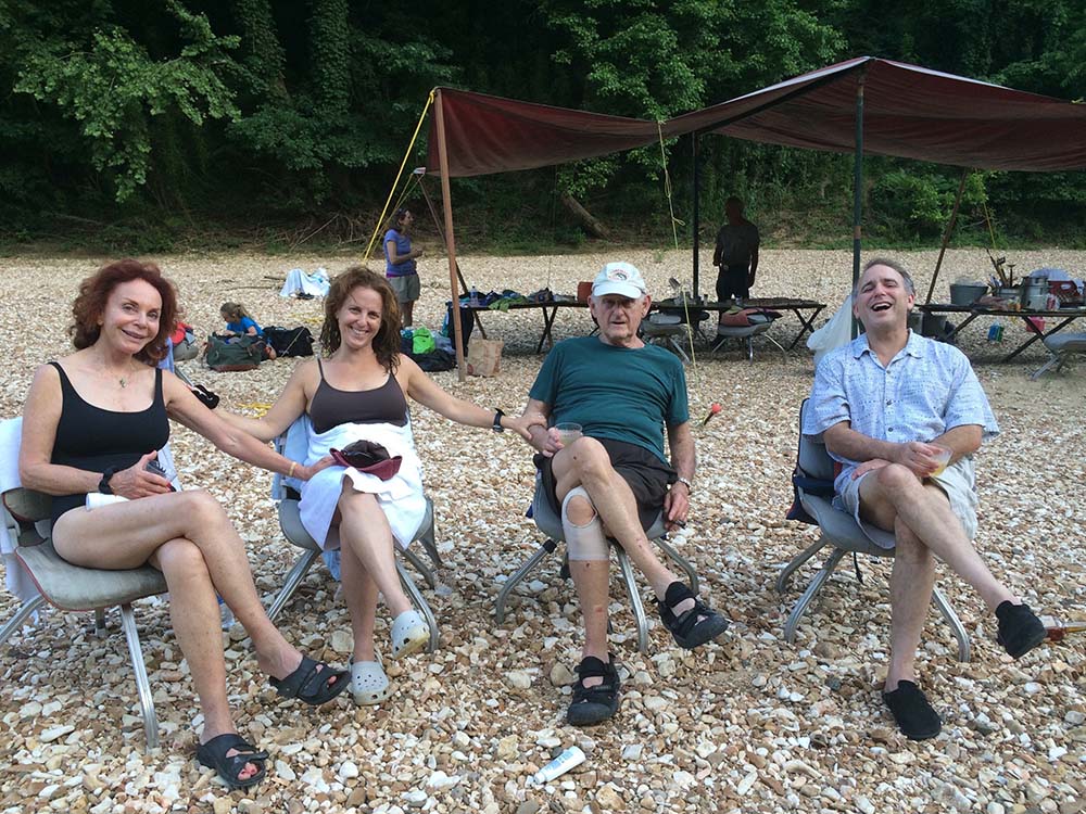 Picture of people sitting next to a river. 